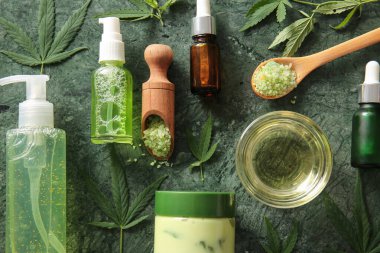 Deniz tuzu ve yeşil arka planda yapraklarla kenevir ürünleri şişeleri ve kavanozu