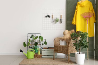 Bahçe aletleri, çivi tahtası ve koltuğu olan odanın içi