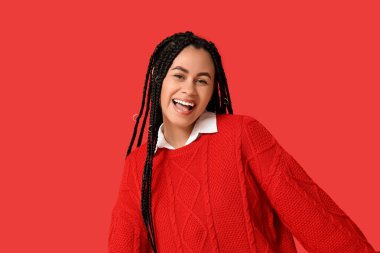 Kırmızı arka planda güzel, mutlu, Afro-Amerikan kadın.