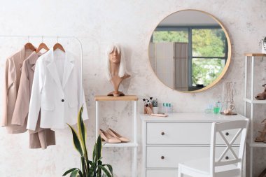 Dolabı, aynası ve peruğu olan hafif makyaj odasının içinde.