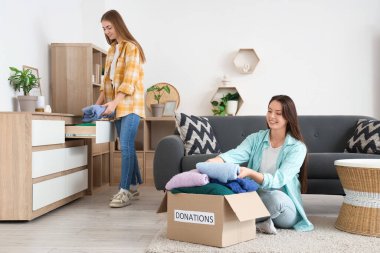 Genç kadınlar elbiselerini evde bağışlıyorlar.