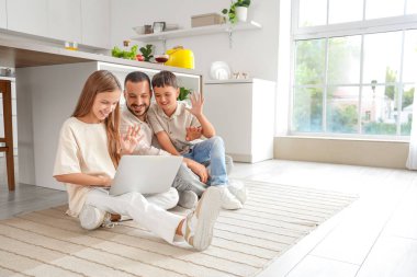 Babaları evde dizüstü bilgisayar kullanan sevimli çocuklar.