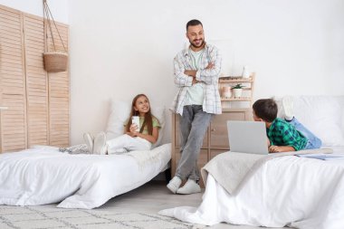 Babaları yatak odasında olan sevimli küçük çocuklar.