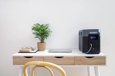 Dizüstü bilgisayarı ve taşınabilir elektrik santrali olan modern işyeri