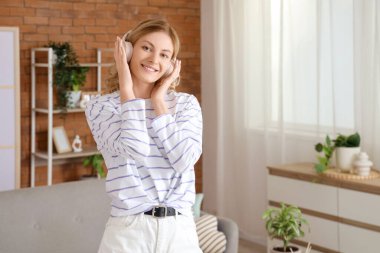 Güzel genç kadın evde müzik kulaklık