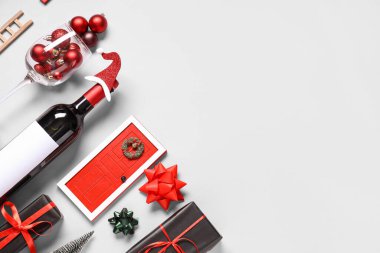 Beyaz arka planda şarap şişesi ve Noel süslemeleri olan kompozisyon