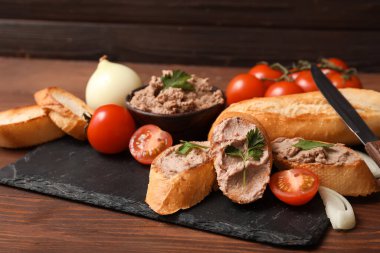 Kızarmış ekmek, lezzetli börek, domates, maydanoz ve ahşap zemin üzerinde soğan.