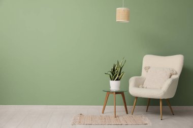 Koltuk, kahve masasında çiçek ve odanın içinde asılı lamba.