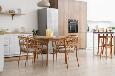 Yemek masasında mumlar olan şık bir mutfak.