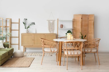 Oturma odasında yemek masasında mumlar var.