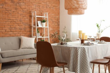 Oturma odasında mumlarla servis edilen yemek masası.