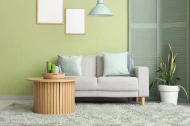 Yumuşak kanepe, katlanan ekran ve oturma odasının içindeki kahve masası.