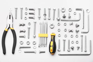 Farklı musluk cıvataları, krom fındıklar ve beyaz arkaplanda izole araçlar düzenleme