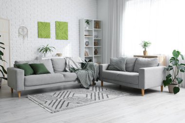 Oturma odasının içinde rahat koltuklar ve resimler var.