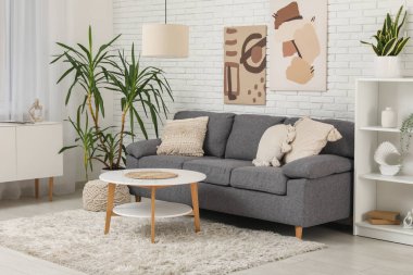 Rahat gri kanepesi ve sehpası olan modern bir oda.