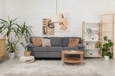 Rahat gri kanepesi ve sehpası olan oturma odasının içinde.