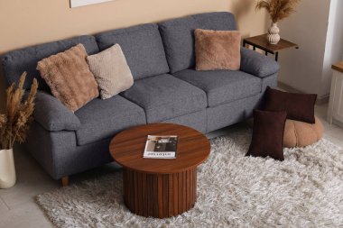 İçinde rahat bir kanepe, kahve masası ve vazolarda otlar olan oturma odası.