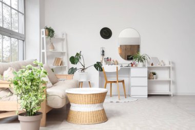 Makyaj masası, raf ünitesi ve kanepesi olan hafif soyunma odası.