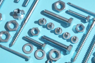 Mavi arka planda farklı musluk cıvataları ve krom fındıklar düzenleme