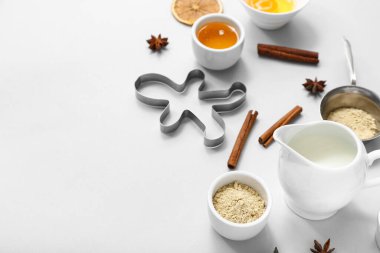 Gri arka planda lezzetli Noel kurabiyeleri ve kesiciler hazırlamak için malzemeler içeren kompozisyon