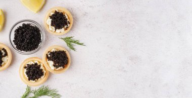 Açık arkaplanda siyah havyarlı lezzetli tartlar ve metin için yer var