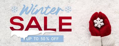 Elleri sıcak eldivenlerde kar taneleri olan kış indirimi afişi.