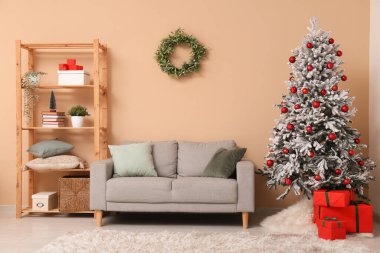 Güzel süslenmiş Noel ağacı ve hediyelerle dolu oturma odasının içinde.