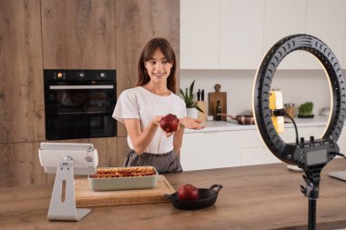 Mutfakta elmalı turta videosu olan genç bir kadın.