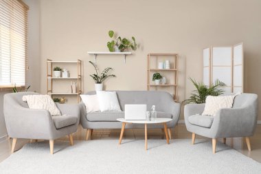 Masanın üzerinde kanepe, koltuk ve aroma spreyi olan bir oturma odası.