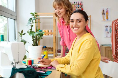 Atölyedeki masada çalışan kadın terziler