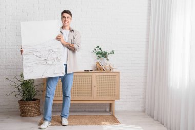 Evinde şık resim yapan genç bir adam.