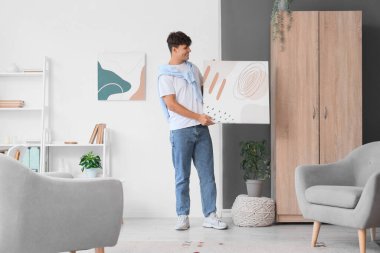 Evinde şık resim yapan genç bir adam.