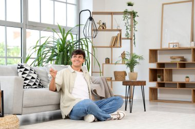 Evdeki klimayı açan yakışıklı genç adam.