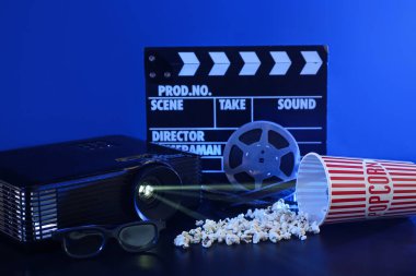 Koyu arkaplanda film, patlamış mısır ve film makaralı film projektörü