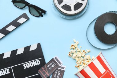 Patlamış mısır, sinema biletleri ve mavi arka planda film makaraları ile film alkışından yapılmış çerçeve