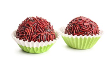 Beyaz arka planda yeşil kağıt bardaklarda lezzetli çikolatalı mantarlar.