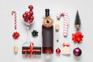 Beyaz arka planda Noel süslemeleri olan bir şişe şarap.
