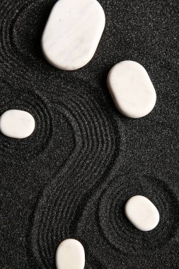 Japon kaya bahçesinde çizgileri olan siyah kumdaki beyaz taşlar. Zen kavramı