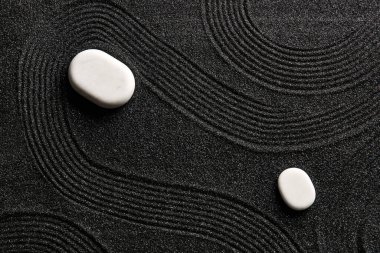 Japon kaya bahçesinde desenli siyah kumlar üzerinde beyaz taşlar. Zen kavramı