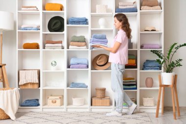 Soyunma odasında elbiseli genç bir kadın var.