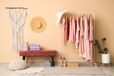 Odadaki bej duvarın yanındaki bankta giysiler ve sıcak süveterler var.