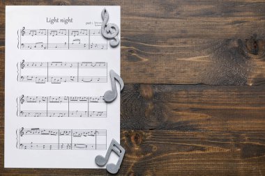 Tahta arkaplanda nota işaretleri olan müzik sayfası