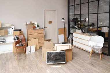 Taşındığı gün karton kutular, mobilyalar ve monitörle sarılı modern ofis.