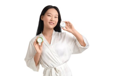 Beyaz arka planda krema kavanozu olan genç Asyalı kadın.