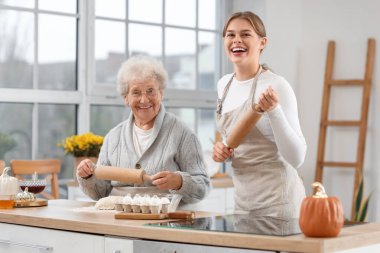 Genç kadın ve büyükannesi mutfakta mangır hazırlıyorlar.