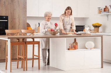 Elmalı son sınıf öğrencisi ve torunu mutfakta hamur topluyor.