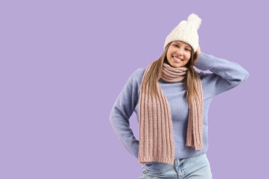 Leylak arka planında, kışlık elbiseli genç bir kadın.