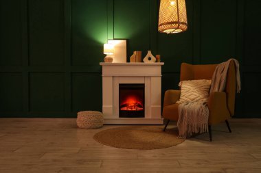 Geceleri şöminesi, koltuğu ve parlayan lambaları olan karanlık oturma odasının içinde.