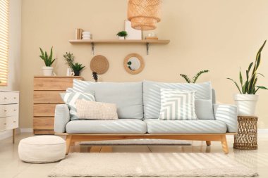 Gri kanepesi, rafı ve bitkileri olan şık bir oturma odası.