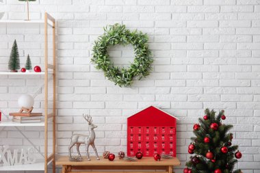 İçinde Noel çelengi, köknar ağacı ve Advent takvimi olan odanın içi